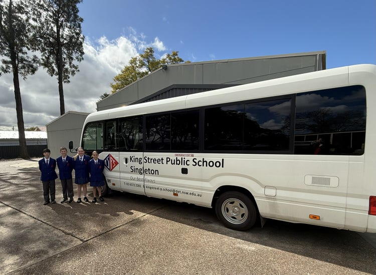 photo of school captains standing near our school bus