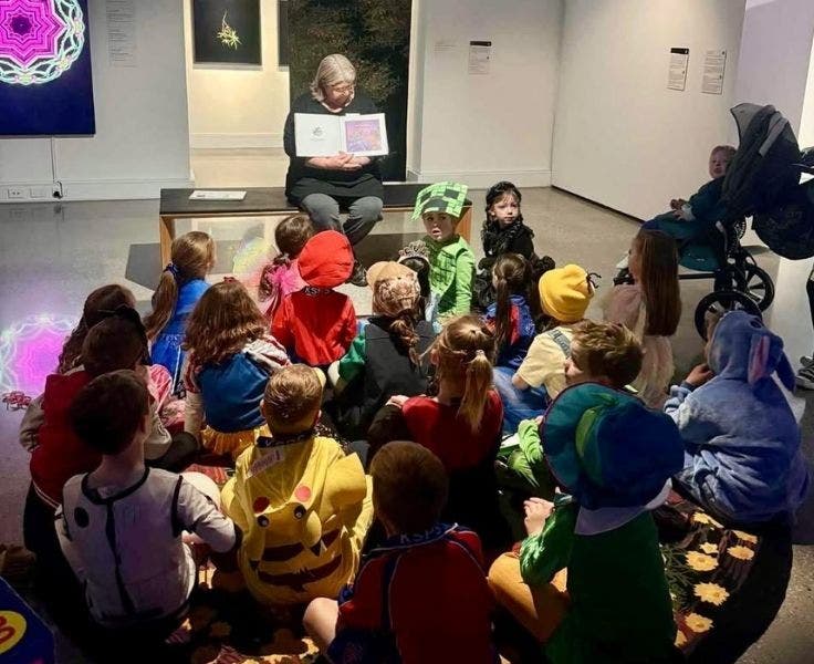 community member reading a book to students